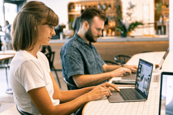 Two Persons Working At A Cafe