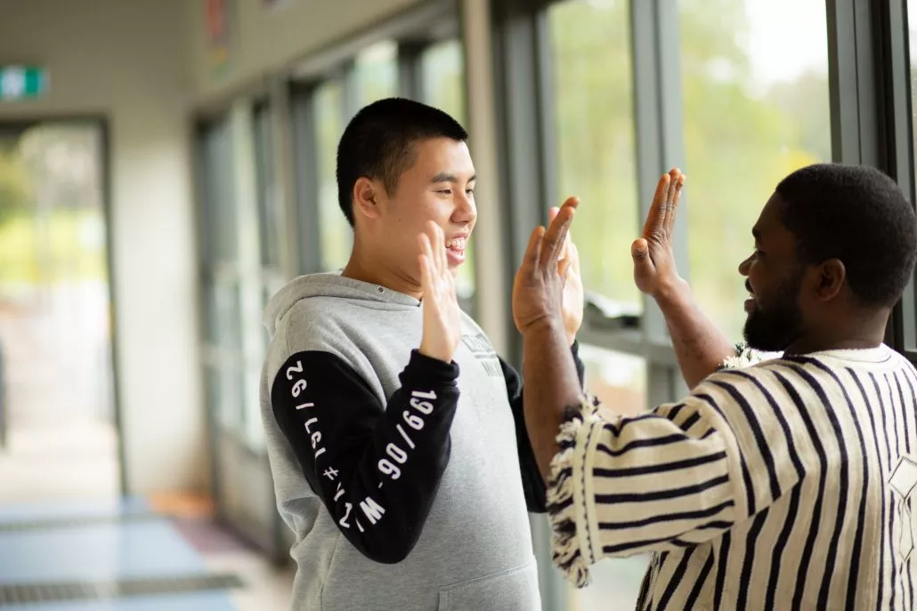 A Young Man With Special Needs Playing High Five with A Volunteer