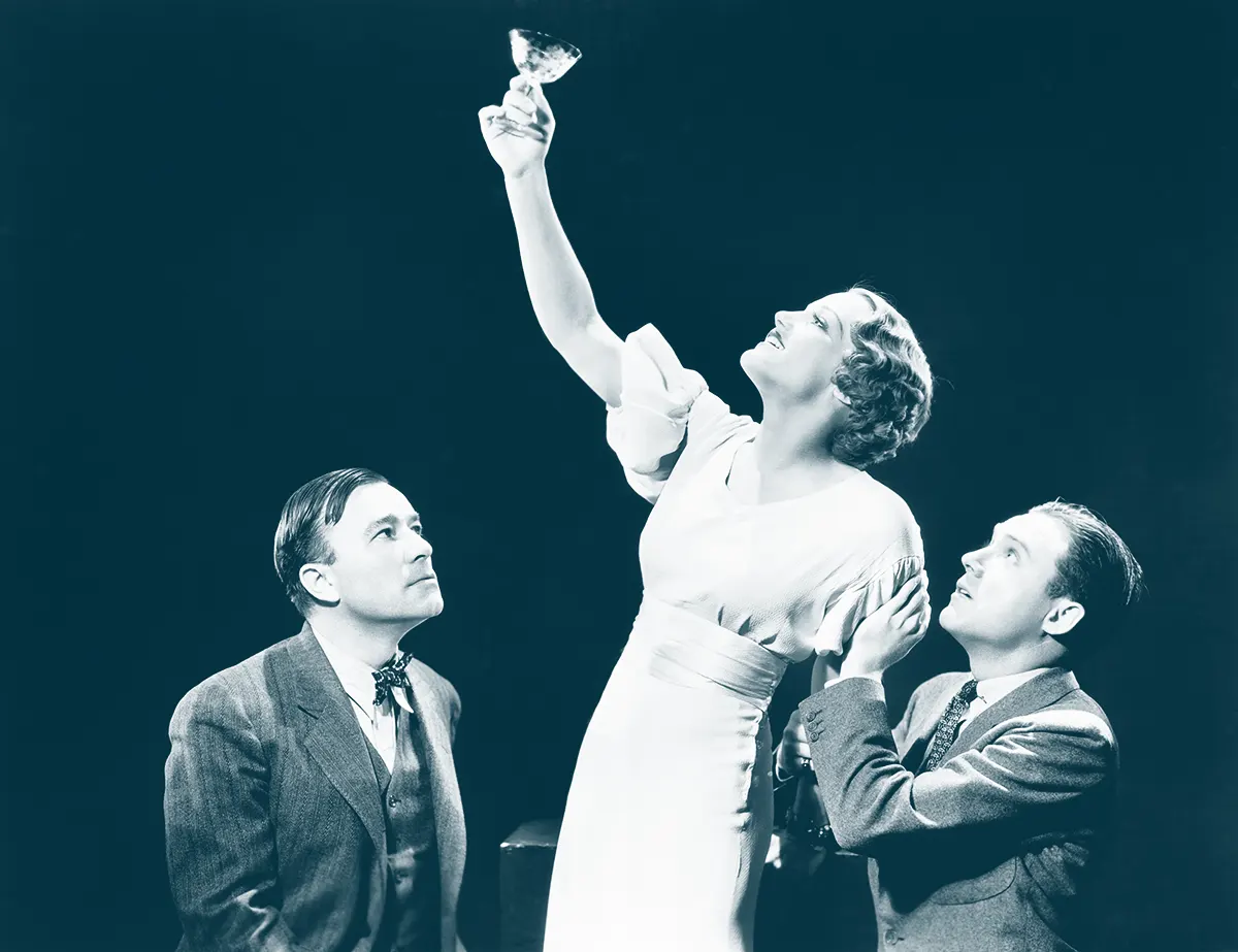 Two Men Sitting and A Woman Raising A Glass