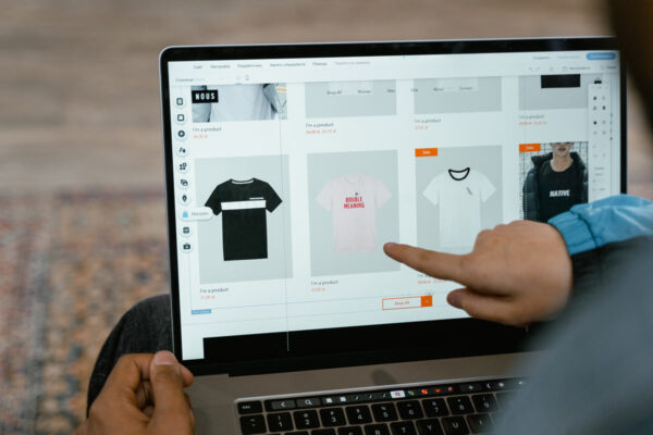 A person browsing shirts online using a laptop
